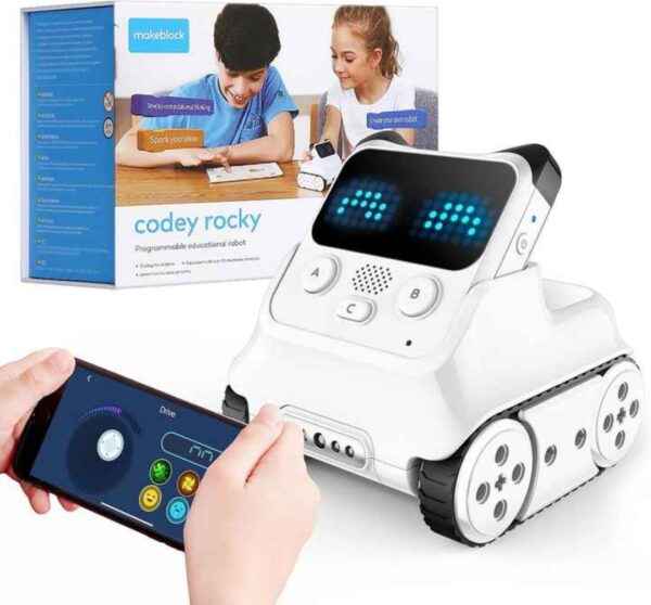 The image shows the Makeblock Codey Rocky, a programmable educational robot. The robot is white with black treads, and features a small screen displaying LED lights. The packaging shows children interacting with the robot and a smartphone app interface is visible, suggesting remote control capabilities. The box indicates it's programmable and educational.